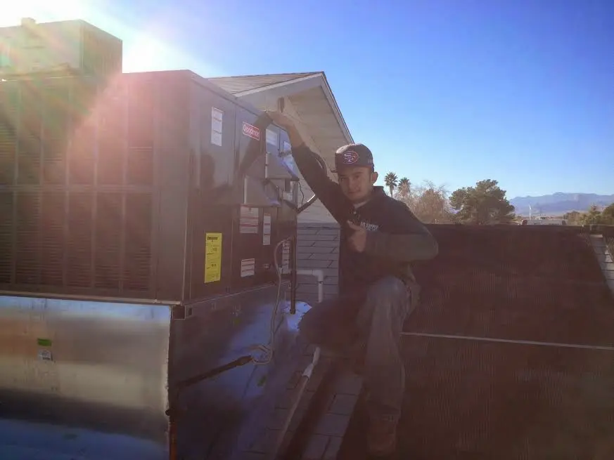 HVAC technician performing AC Tune-Up on a rooftop unit in Arlington